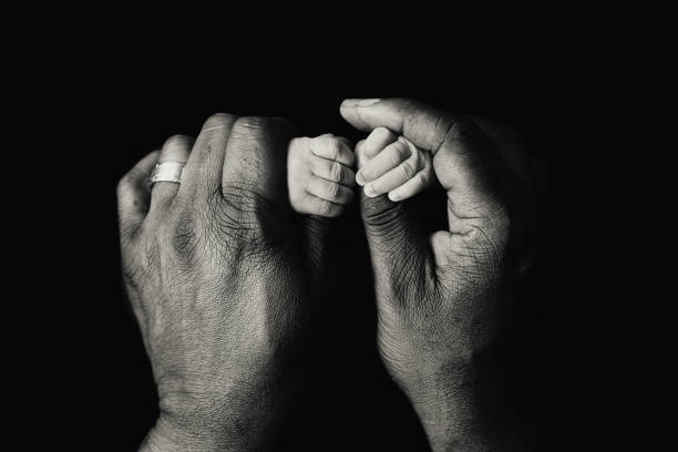 Baby holding mother finger