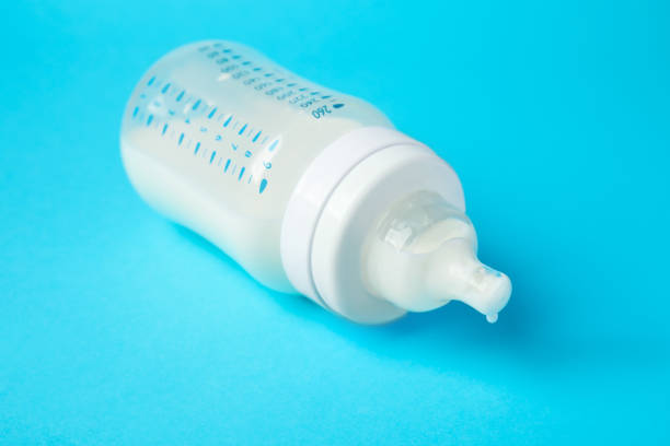 istock One feeding bottle with milk on light blue background, closeup 1793529847