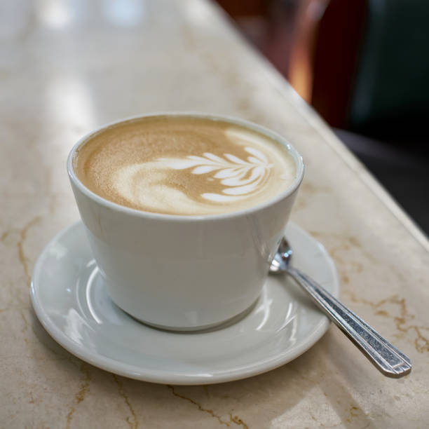 A cup of latte macchiato on a table in a cafe A cup of latte macchiato on a table in a cafe in the old town of Prague aromatisch stock pictures, royalty-free photos & images