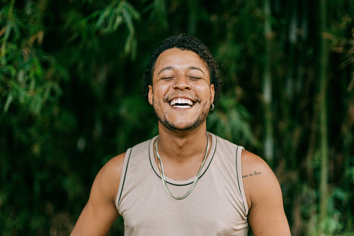 Smiling young man wearing a t-shirt in the background of a bamboo forest