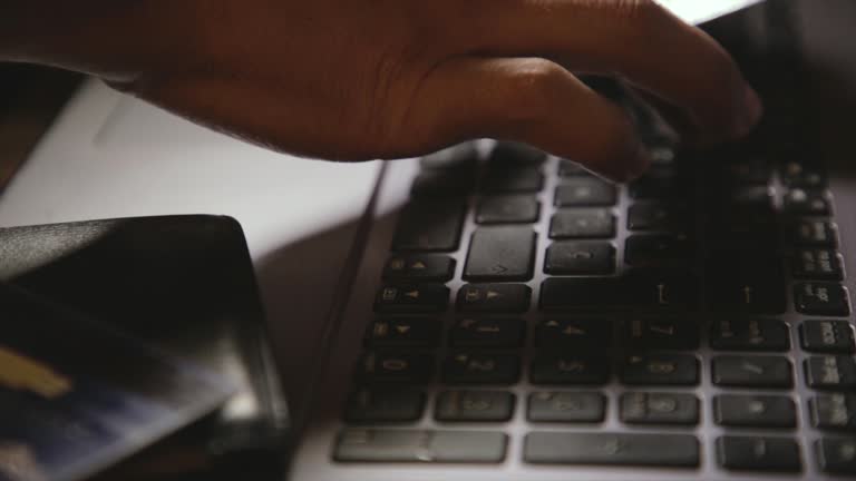 Hands holding a credit card and using a laptop. Online shopping.