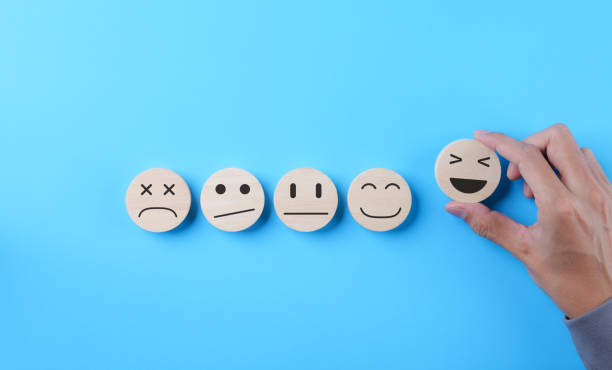 istock Customer review satisfaction feedback survey concept. Hand picked happy smile face icon on wooden sphere with on light blue background. Client questionnaire, Service rating user, Business evaluation, 1793564108