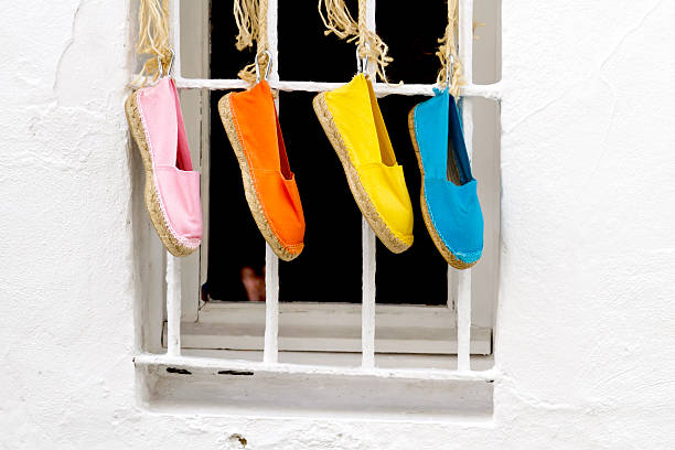 Four shoes hanging Four brightly colored traditional spanish shoes hanging outside a window flat shoe photos stock pictures, royalty-free photos & images