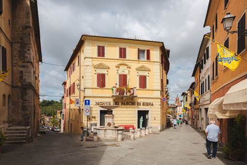 Asciano, Italy - August 30, 2023: Main street and old town centre of the quaint and charming, historic Tuscan village of Asciano, Tuscany.