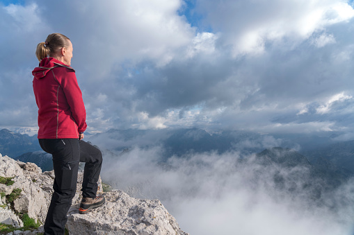 Women enjoying the view high up the lake of fog from the top of Mount Krn, Julian Alps, Slovenia