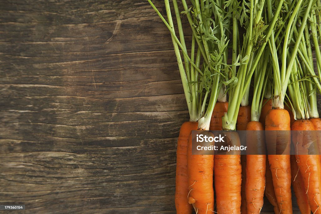 Fresh carrots on wooden background Carrot Stock Photo