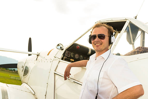 istock A pilot wearing headphones leaning on his plane 179360929
