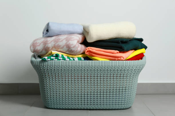 istock Plastic laundry basket with clean clothes on floor indoors 1793610102