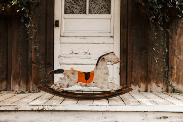 A wooden antique rocking horse on a rustic porch.