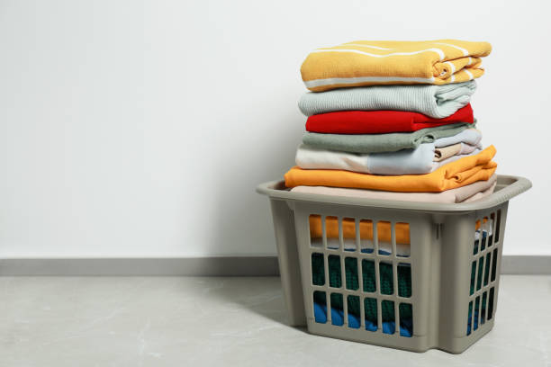 istock Plastic laundry basket with clean clothes on floor indoors, space for text 1793611811
