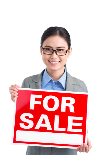 Beautiful young woman holding an open sign at a grocery store - small business concepts