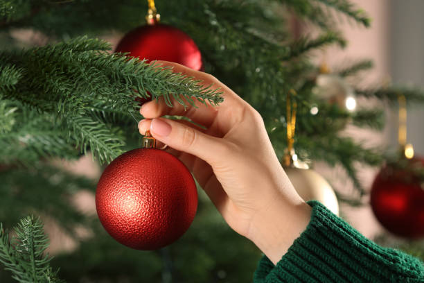 istock Woman decorating Christmas tree with beautiful red bauble, closeup 1793617424