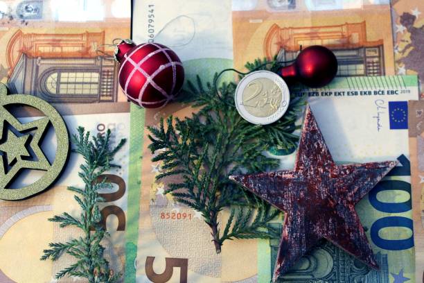 Christmas money: Euro bills and coins, decorated with Christmas decoration. It symbolizes both a Christmas bonus for workers and employees as well as gifts of money. Christmas money: Euro bills and coins, decorated with Christmas decoration. It symbolizes both a Christmas bonus for workers and employees as well as gifts of money. euro bill in a christmas ornament stock pictures, royalty-free photos & images