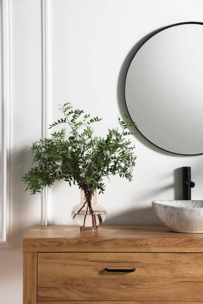 istock Modern bathroom interior with stylish mirror, eucalyptus branches, vessel sink and wooden vanity 1793638461