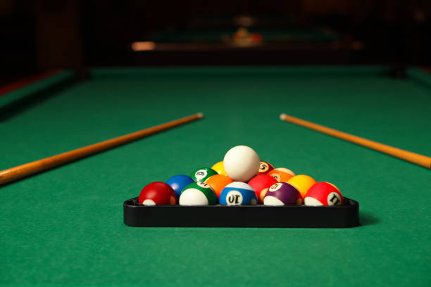 istock Plastic triangle rack with billiard balls and cues on green table indoors 1793640625