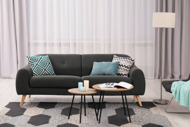 istock Comfortable sofa, floor lamp and coffee table in stylish room. Interior design 1793641159