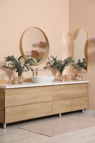 istock Modern bathroom interior with stylish mirror, eucalyptus branches, vessel sink and wooden vanity 1793643339