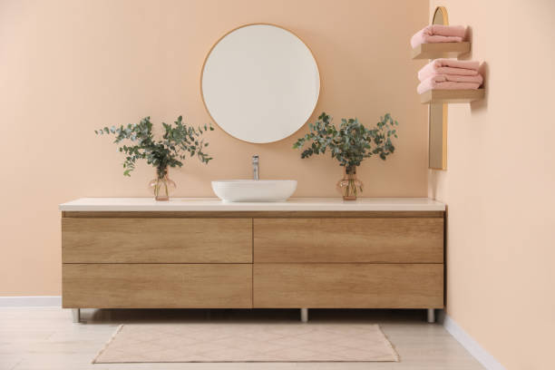 istock Modern bathroom interior with stylish mirror, eucalyptus branches, vessel sink and wooden vanity 1793643820