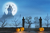 Halloween pumpkins next to a gate of a spooky castle
