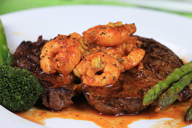 surf and turf - surf and turf prepared shrimp steak grilled fotografías e imágenes de stock