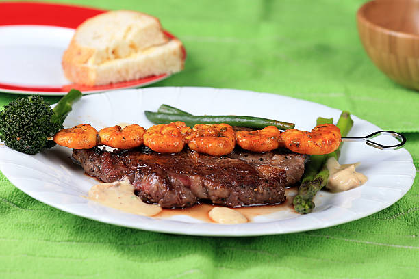 surf and turf - surf and turf prepared shrimp steak grilled fotografías e imágenes de stock