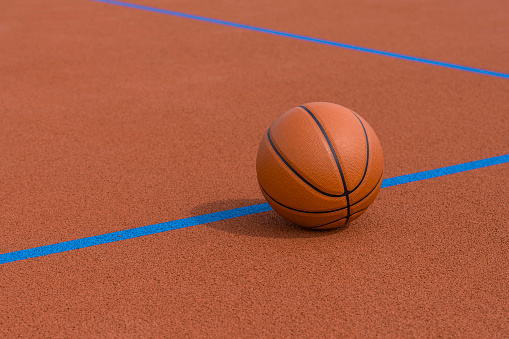 New orange basketball with blue line on orange court of gymnasium sport floor. Horizontal sport theme poster, greeting cards, headers, website and app