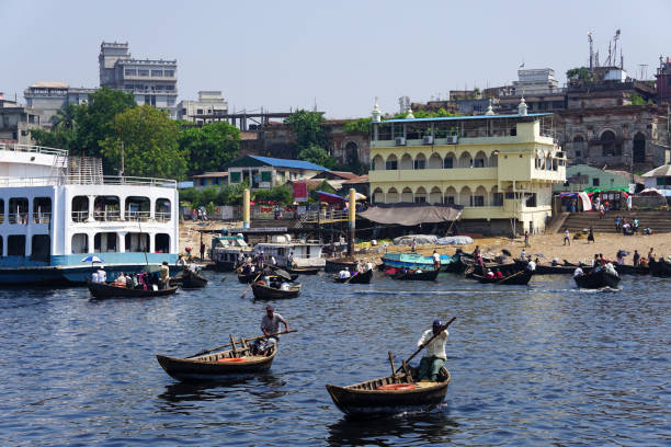 Sadarghat, Dhaka, Bangladesh (04-08-2022) \nSadarghat riverview landscape, Transporting local people by small boats across the river, Commuter ferryboat in the monsoon, Boat ride in the Buriganga river