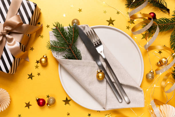 istock Festive table setting plate, gift and Christmas decor on yellow background, invitation dinner birthday party anniversary. top view 1793681388