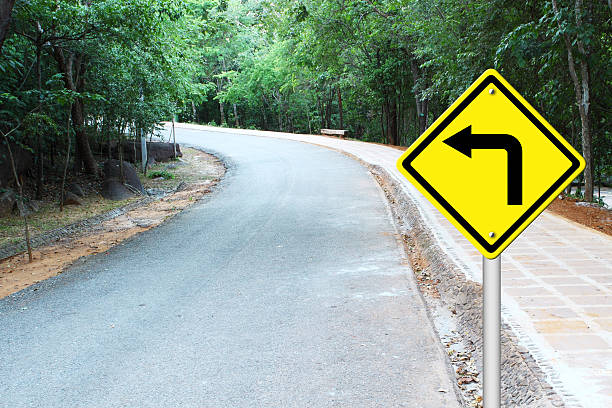 istock Turn left warning sign on curve road 179369060