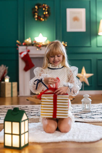 istock Cute girl unwrapping presents 1793707179