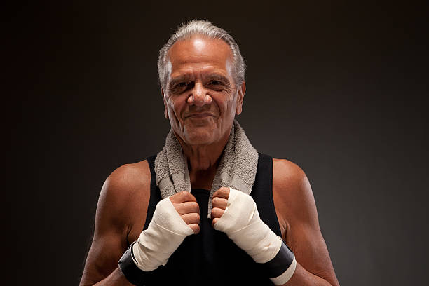 smiling senior fighter with a towel Senior fighter with a towel old man boxing stock pictures, royalty-free photos & images