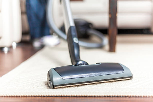 istock A woman vacuuming her white carpet 179372912