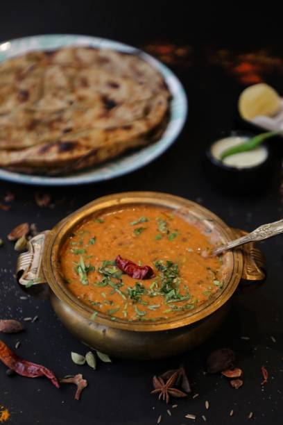 Dal makhani with lacha paratha in background