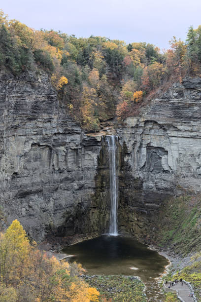 istock waterfall at Taughannock Falls State Park (huge beautiful gorge) Finger Lakes (Ithaca, New York State) autumn view with fall foliage (colorful changing leaves) stone, rock, slate, glacial formed 1793740388
