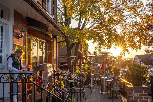 Doylestown, USA - November 5, 2023. People dining outdoor at Penn Taproom at Sunset in historic district of downtown Doylestown, Pennsylvania, USA