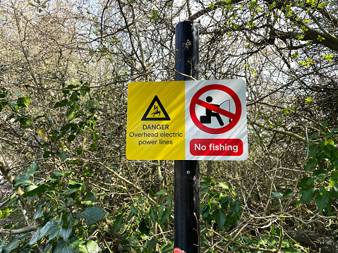 Danger confined space sign on a fence around a man hole