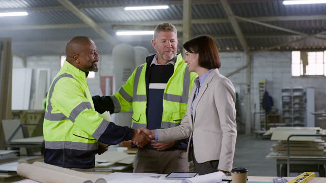 Engineer men, woman and handshake at architect agency, workshop and welcome with introduction. Technician, client and shaking hands for deal, agreement or happy for construction proposal in warehouse