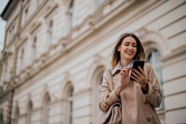 istock Stylish woman using applications on a smartphone while walking outside 1793783990
