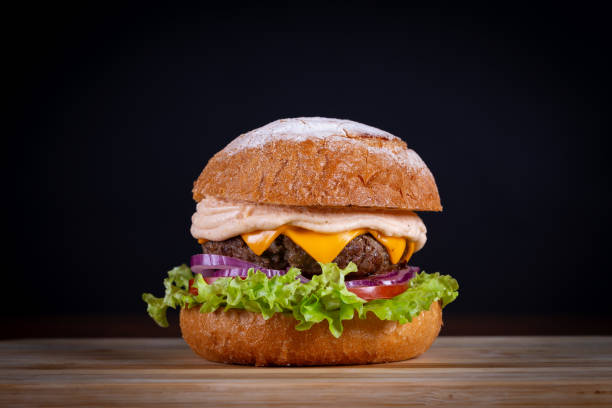 istock Beef burger with lettuce, tomato, cheddar cheese and onion 1793797897