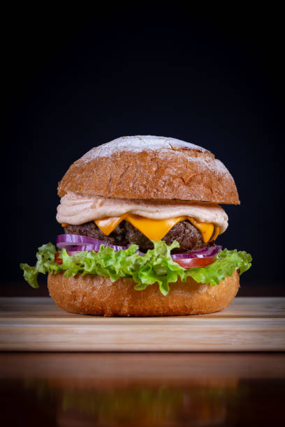 istock Beef burger with lettuce, tomato, cheddar cheese and onion 1793797901