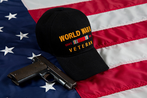 USA Second Amendment constitutional Right to Bear Arms. Antique firearm and veterans cap resting on an American Flag.