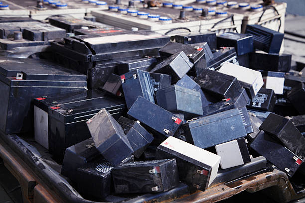 Used batteries piled randomly in big container stock photo