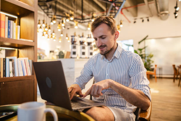 istock Handsome young white man doing work on a laptop in a cafe 1793848998