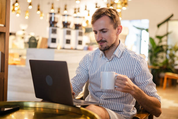 istock Handsome young white man doing work on a laptop in a cafe 1793849549