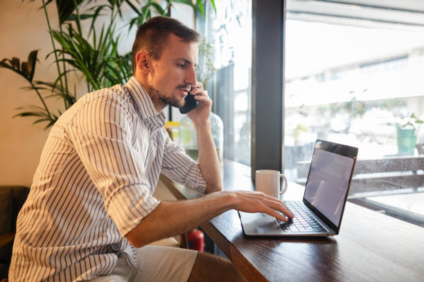 istock Handsome young white man doing work on a laptop in a cafe 1793850079