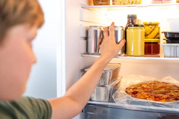 istock White kid grabbing a soda can from the refrigerator 1793857927