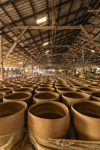 Rows of terracotta water jars, a work in process at a traditional Thai-style dragon jar factory in Ratchaburi province, Thailand
