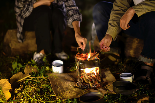 Close-up of barbecue meal grill in the wilderness of backpacker group. Grilled meals ready to eat for hiking groups, Camping in nature, Cooking at night with an atmosphere that is warm and inviting.