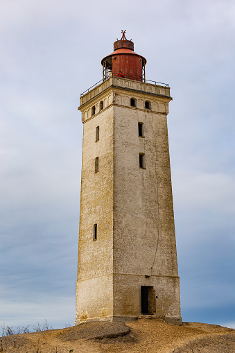 Rubjerg Knude Lighthouse, Denmark A view of the famous Rubjerg Knude lighthouse that was moved due to dune and water erosion in 2018, and people walking.
