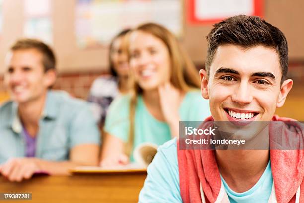 Mężczyzna Student Uśmiech Z Uczniów W Tle W Sala Wykładowa - zdjęcia stockowe i więcej obrazów 16-17 lat